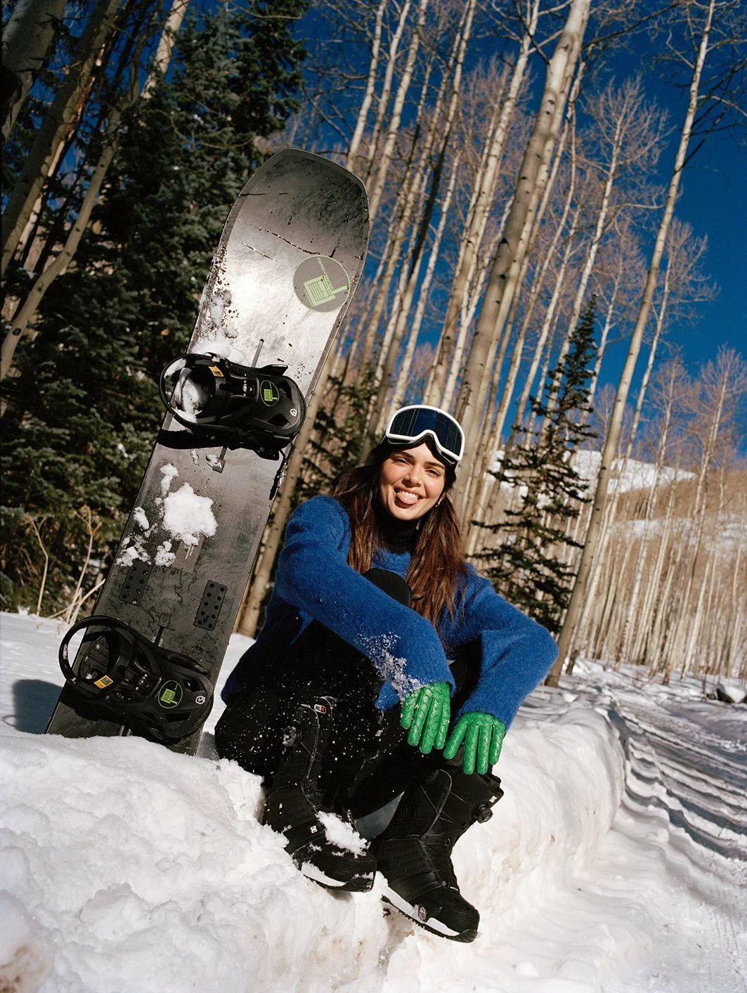  Kendall Jenner in a blue ski look seated beside a snowmobile in Aspen for FWRD, photographed by Sean Thomas. 