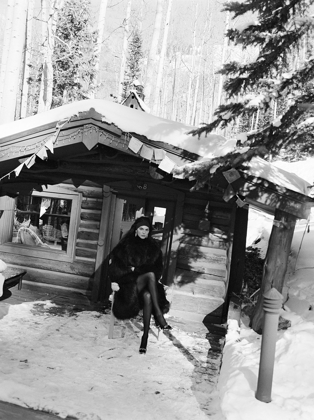  Black-and-white portrait of Kendall Jenner outside a snow-covered Aspen lodge for the FWRD campaign, photographed by Sean Thomas. 