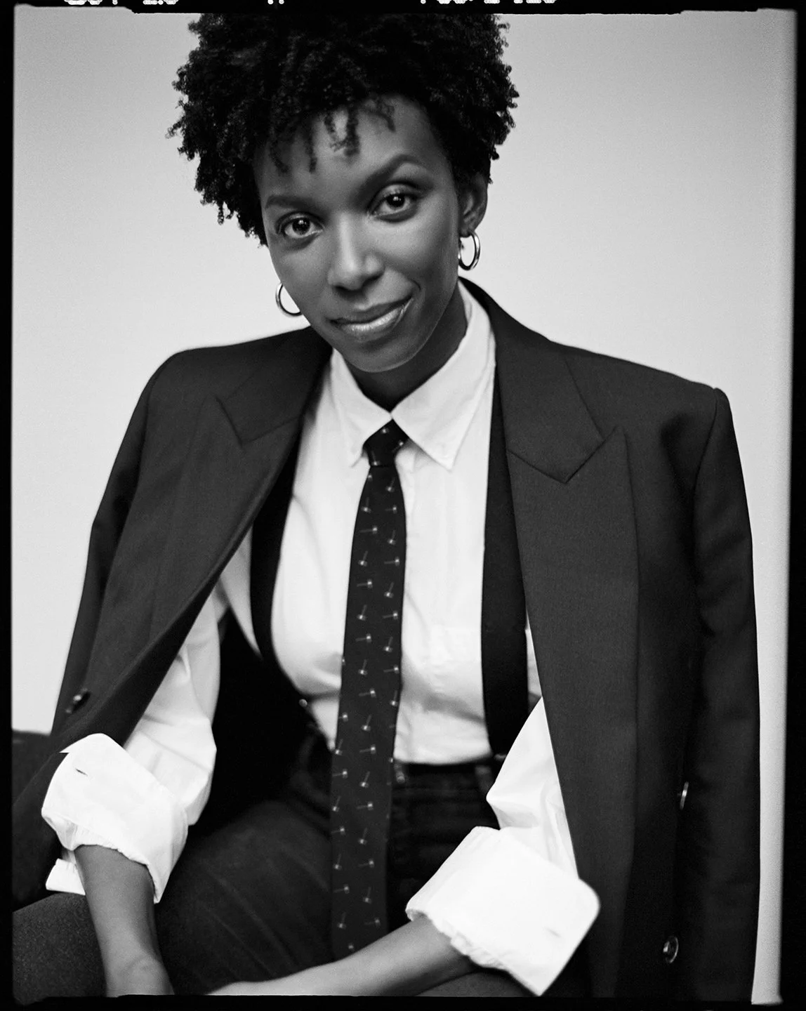  Black-and-white portrait of Sotheby’s auctioneer Kimberly Pirtle in a tailored suit and tie, photographed by Sean Thomas. 