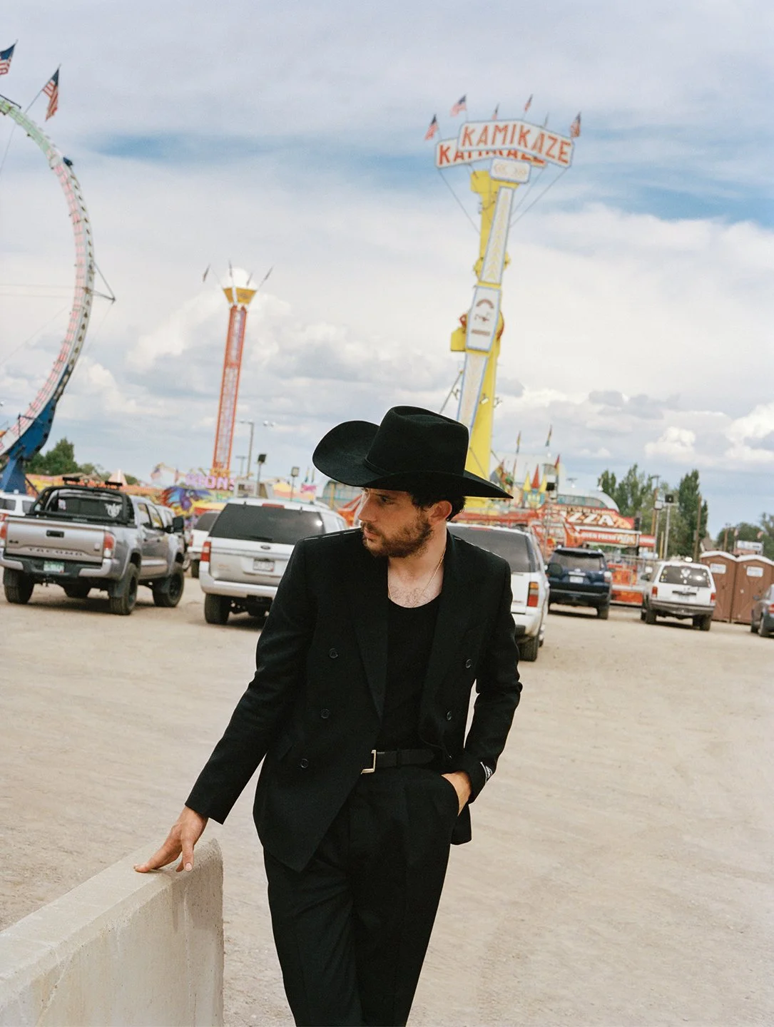  Josh O’Connor in a black suit and cowboy hat at a Colorado carnival, photographed by Sean Thomas for WSJ. Magazine. 