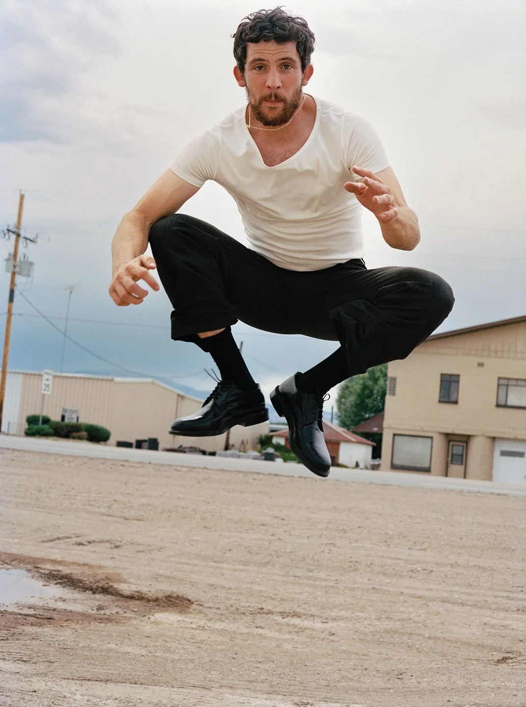  Josh O’Connor jumping above an unpaved street in Monte Vista, Colorado, photographed by Sean Thomas for WSJ. Magazine. 
