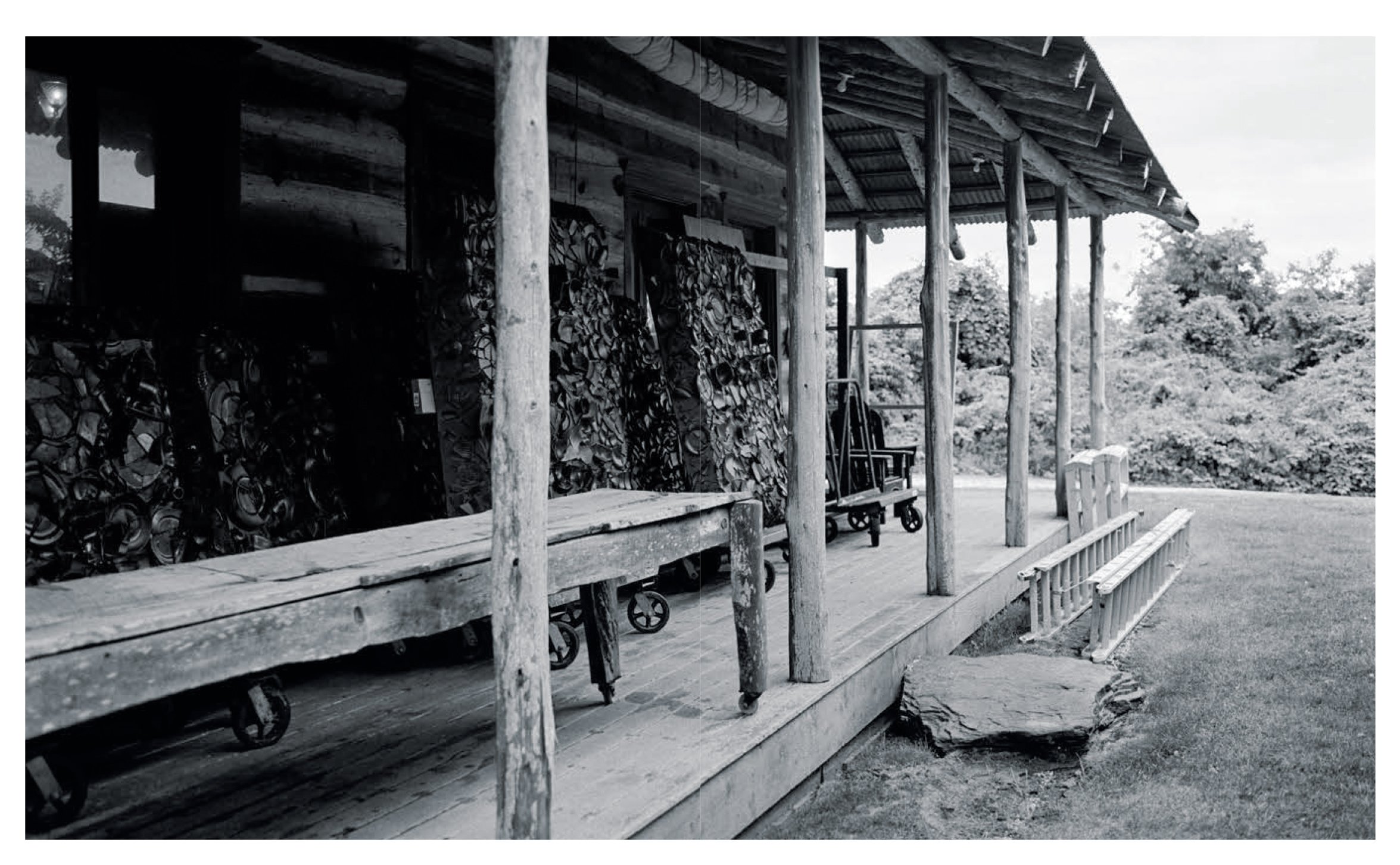  Black-and-white view of the rustic porch and artworks at Julian Schnabel’s Montauk studio, photographed by Sean Thomas for Door, La Repubblica. 