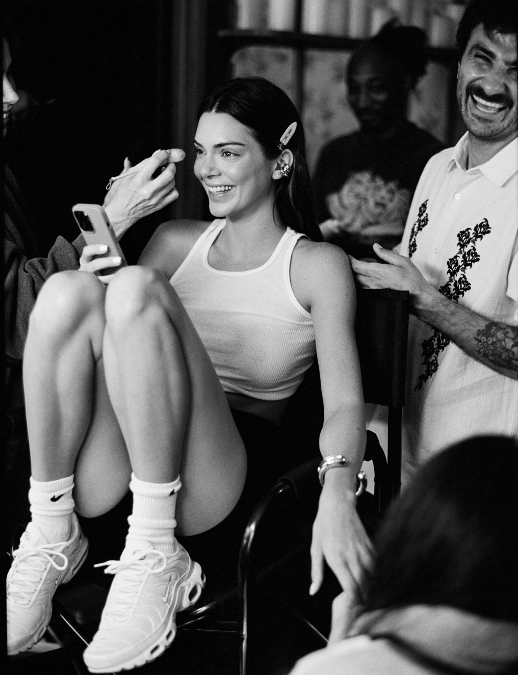  Black-and-white behind-the-scenes portrait of Kendall Jenner smiling in the makeup chair during her WSJ. Magazine shoot with photographer Sean Thomas in Los Angeles. 