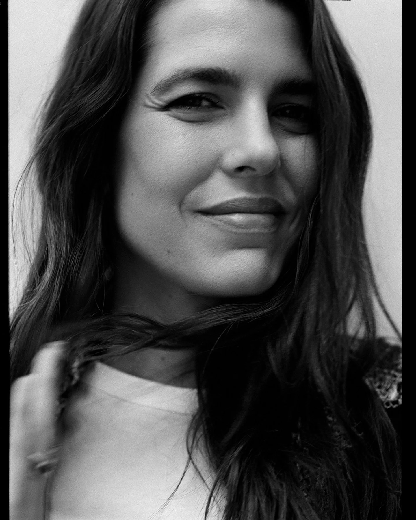  Black-and-white close portrait of Charlotte Casiraghi looking toward the camera, photographed by Sean Thomas for d la Repubblica. Makeup by Lili Choi and hair by Thibaud Salducci; Chanel Beauty. 