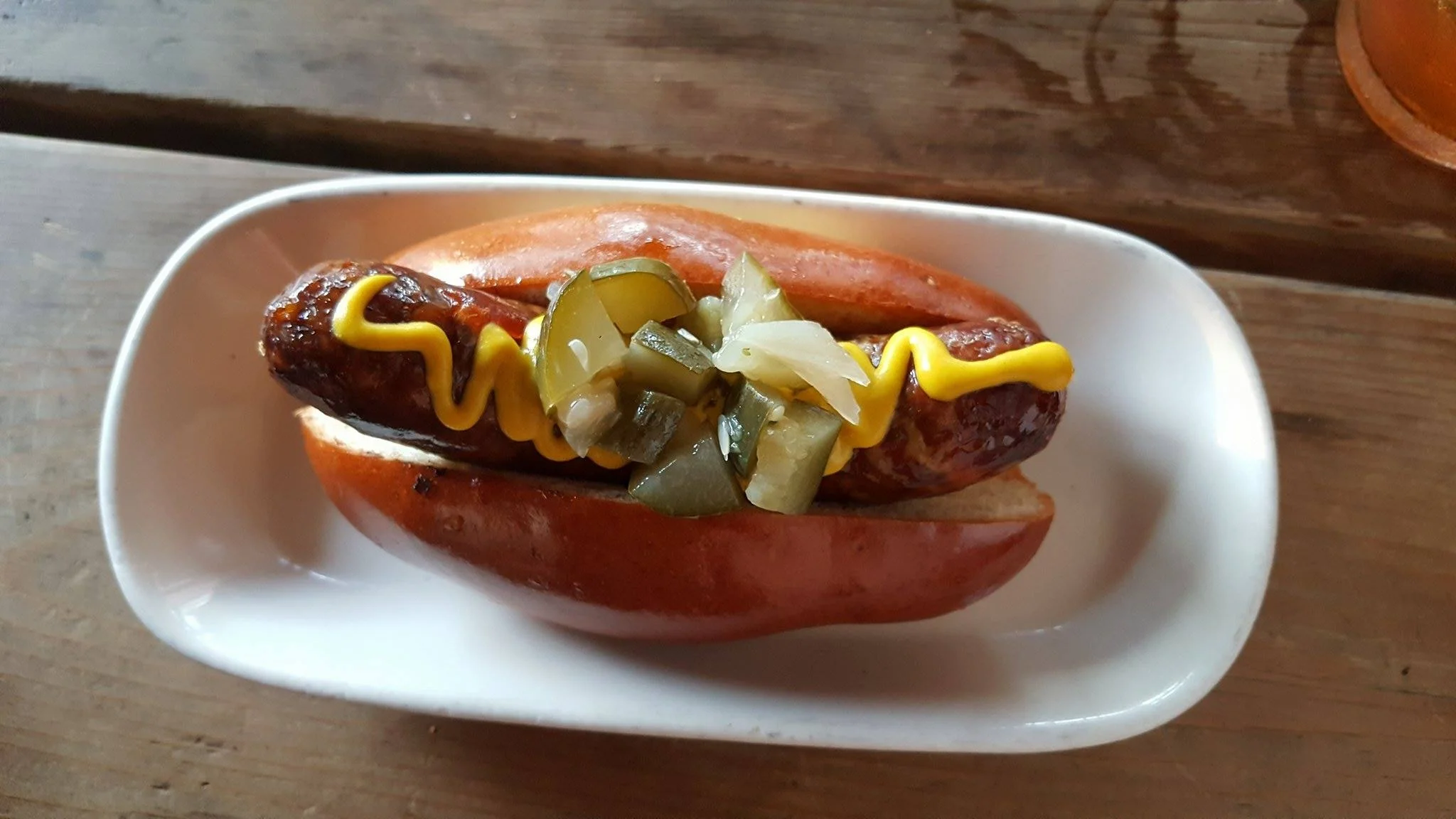House-made sausage. Brisket, jalapenos, cheddar, pickles, pretzel bun