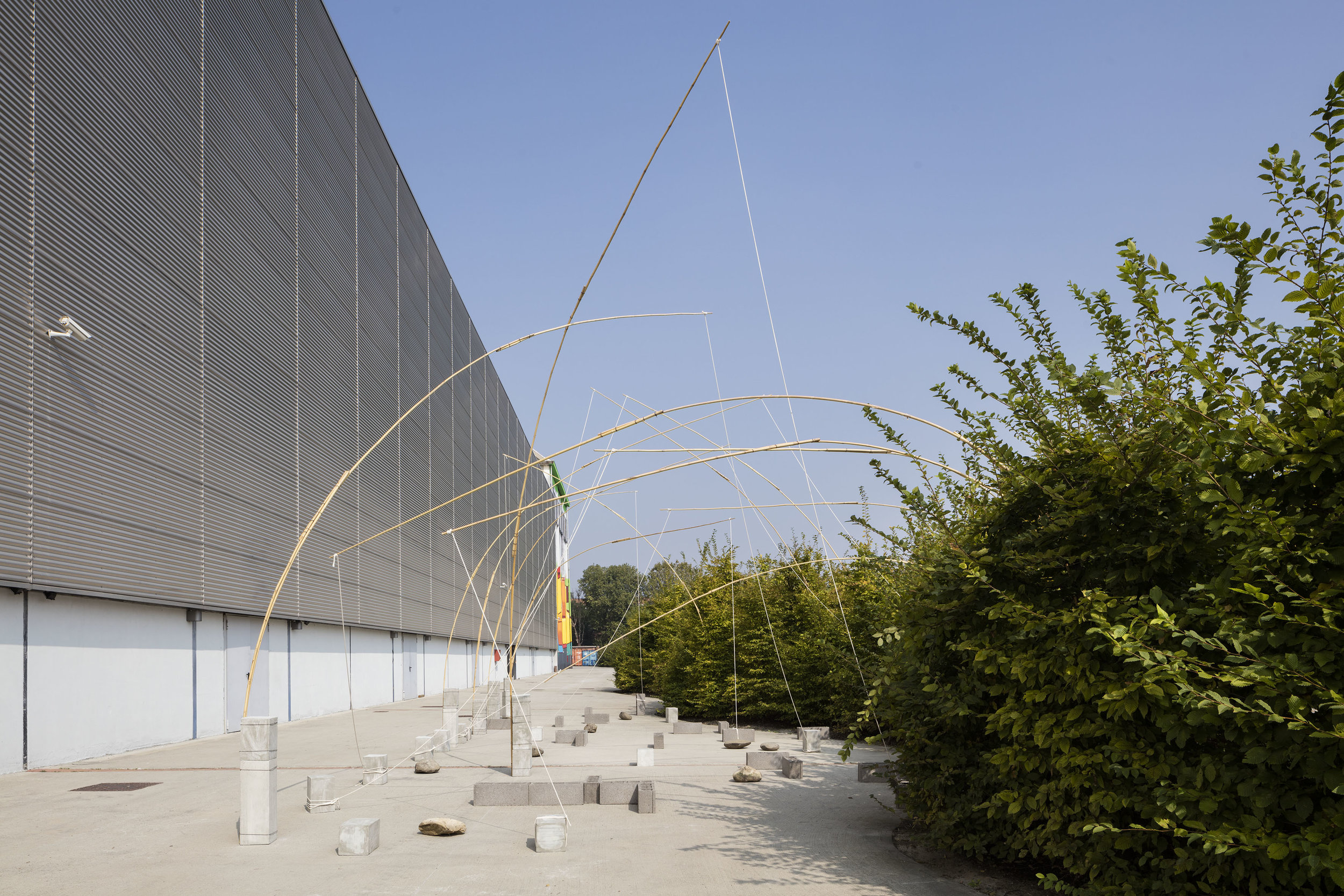 Unfolding Field , 1972/2016 野展 ( Noten ) bamboo, rope, stones, cement blocks 500 x 2000 x 700 c Installation view, Kishio Suga: Situations , Pirelli HangarBicocca, Milan, 2016 Photo: Agostino Osio; Courtesy Pirelli HangarBicocca, Milan