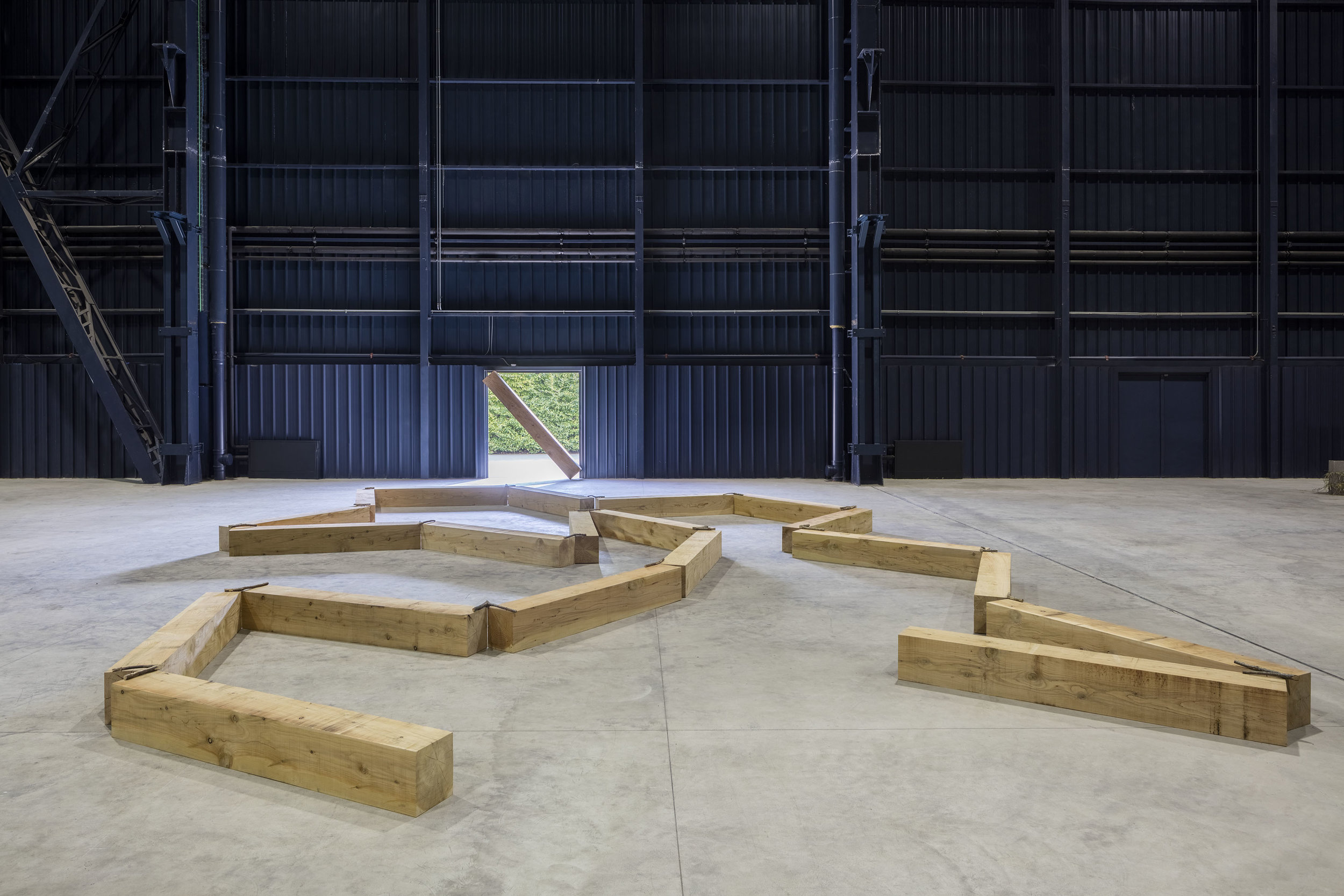Contorted Positioning , 1982/2016 曲位 ( Kyokui ) Wood, twigs 27 x 1000 x 800 cm Installation view, Kishio Suga: Situations , Pirelli HangarBicocca, Milan, 2016 Photo: Agostino Osio; Courtesy Pirelli HangarBicocca, Milan