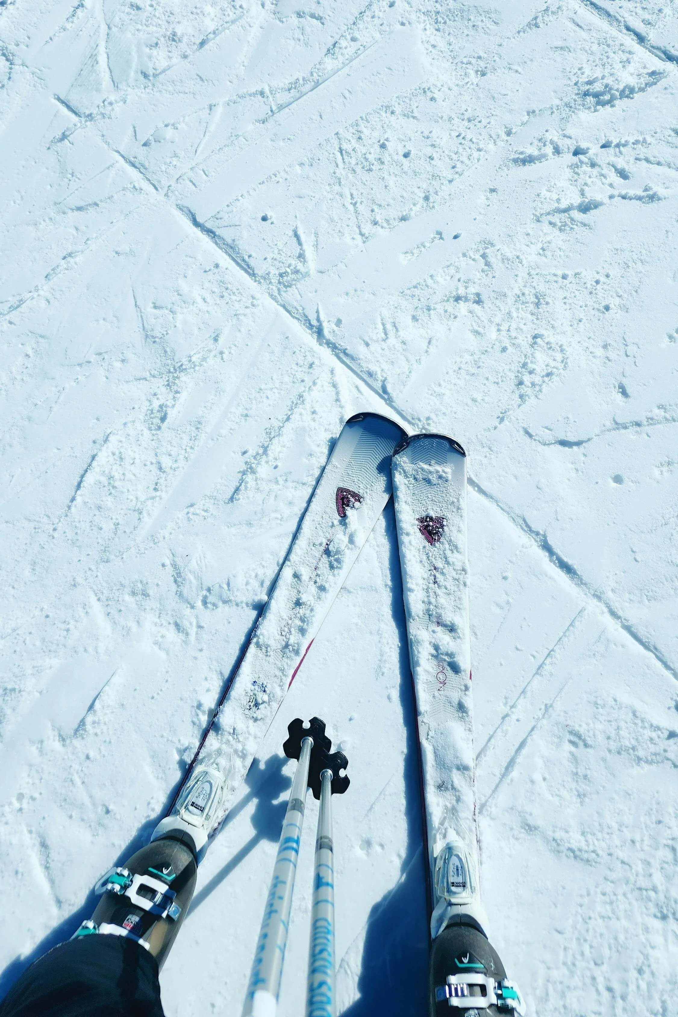 Looking down onto skis on snow. Represents therapy for chronic illness or in jurisdictions in Seattle.