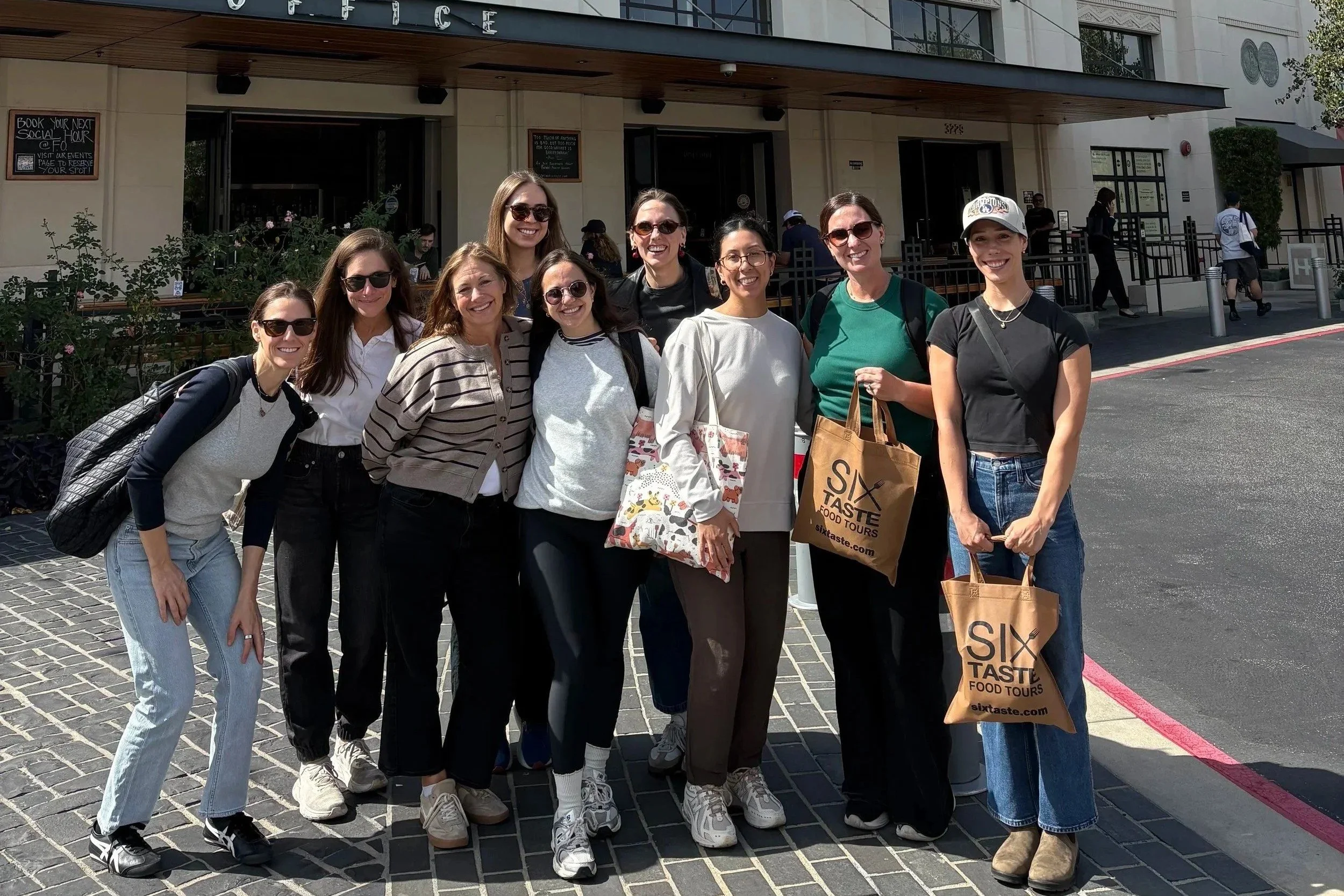 TLA Therapy team smiling together outside the historic Helms Bakery building in Los Angeles.