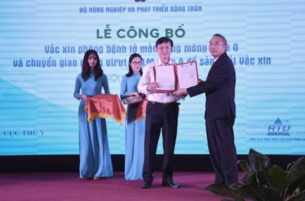 Thứ trưởng Bộ NN&PTNT Phùng Đức Tiến trao quyết định của Bộ NN&PTNT về việc công nhận giống vi rút LMLM type A RAHO6/FMD/A-379 để sản xuất vắc xin - Ảnh : K. LỰC
