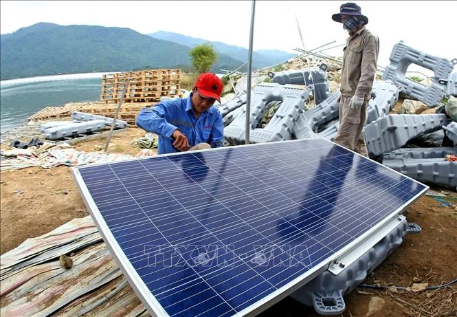 Những tấm pin mặt trời của nhà máy điện mặt trời nổi đang được lắp đặt trên mặt hồ thuỷ điện Đa Mi.