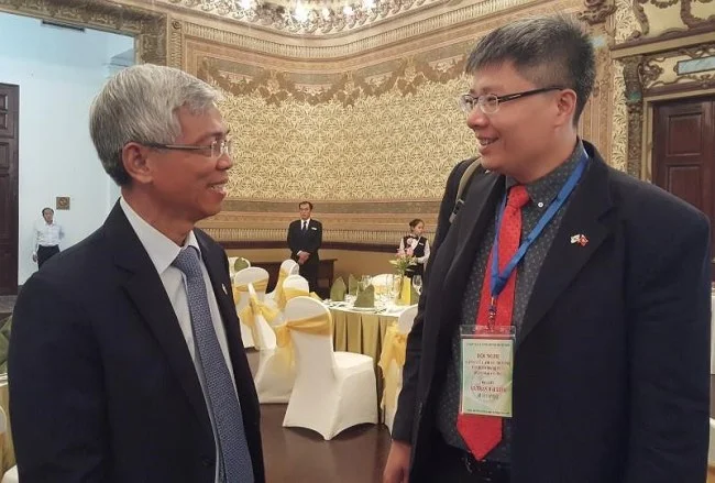 Giáo sư Trần Hải Linh trao đổi với ông Võ Văn Hoan, Chánh Văn phòng UBND TP.HCM bên lề hội nghị. Ảnh: TÁ LÂM