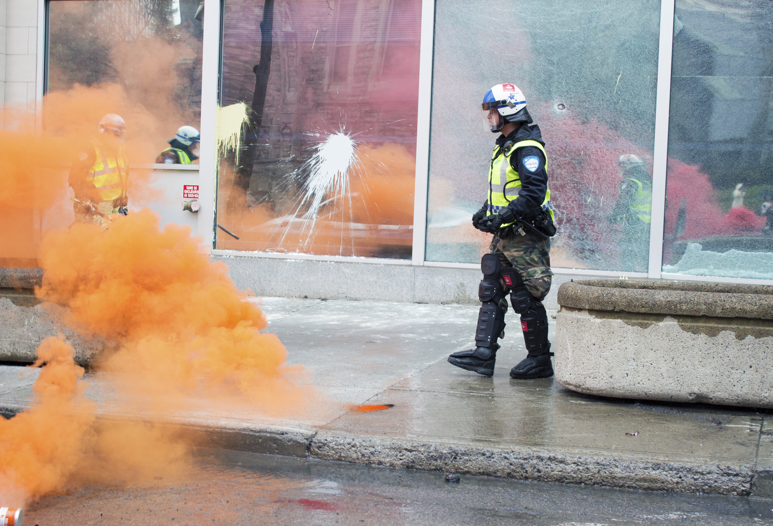  Police officer walks past a damaged police station during an anticapitalist May Day demonstration in downtown Montreal (May 1 2016)&nbsp; 