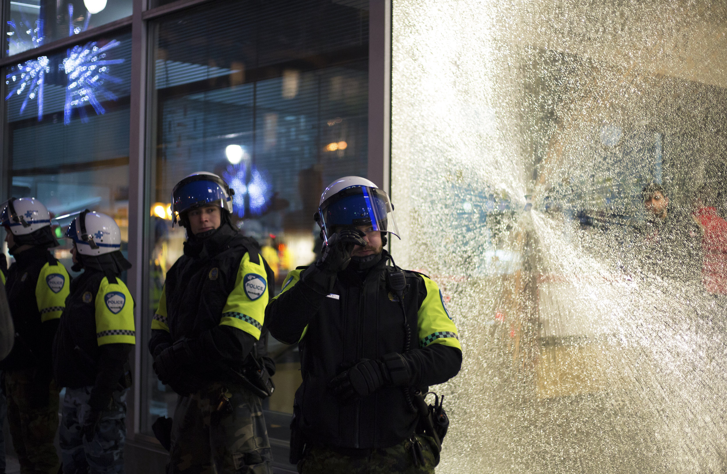  SPVM officers guard a police station after attacked by demonstrators during a protest against Donald Trump in downtown Montreal (January 21 2017)&nbsp; 