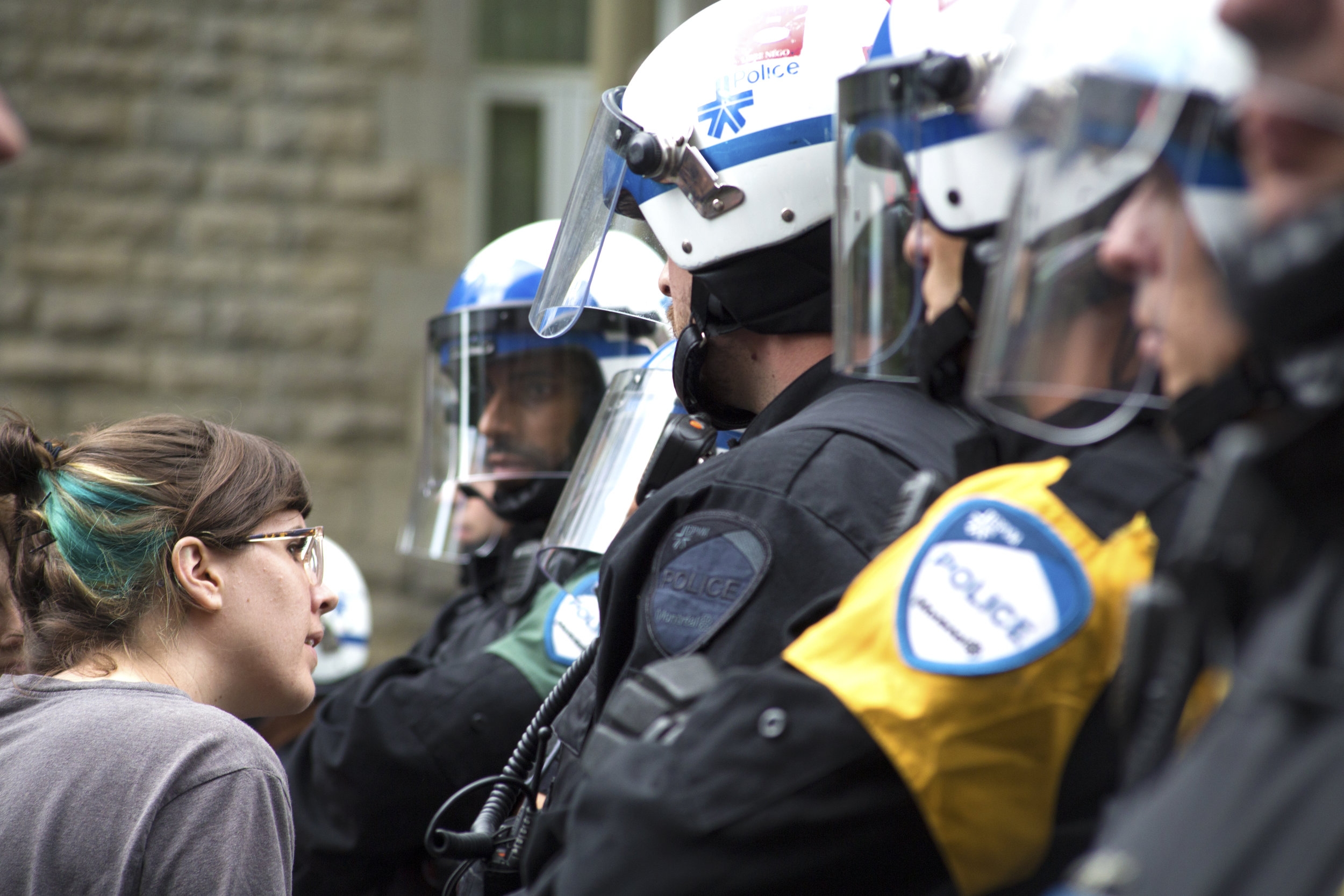  Protester peers through a line of riot police at a demonstration and occupation in favour of increased investment in public housing (May 24 2017)&nbsp; 