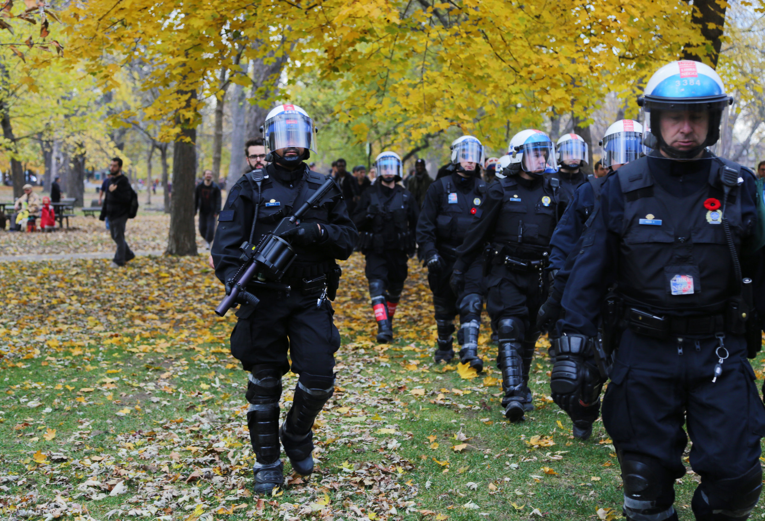  Montreal riot police walk through a park in autumn during a demonstration for increased public funding. (November 5 2015)&nbsp; 