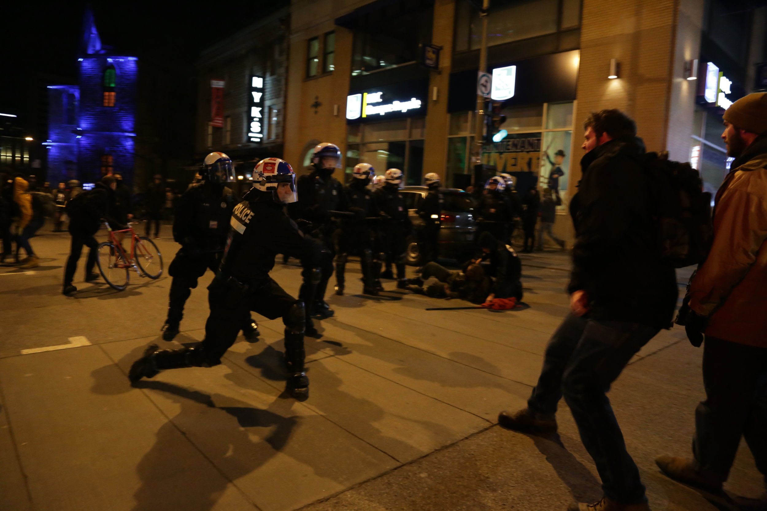  Montreal Police (SPVM) officer swings a baton at a protester during a demonstration against public sector budget cuts. November 30 2015.  