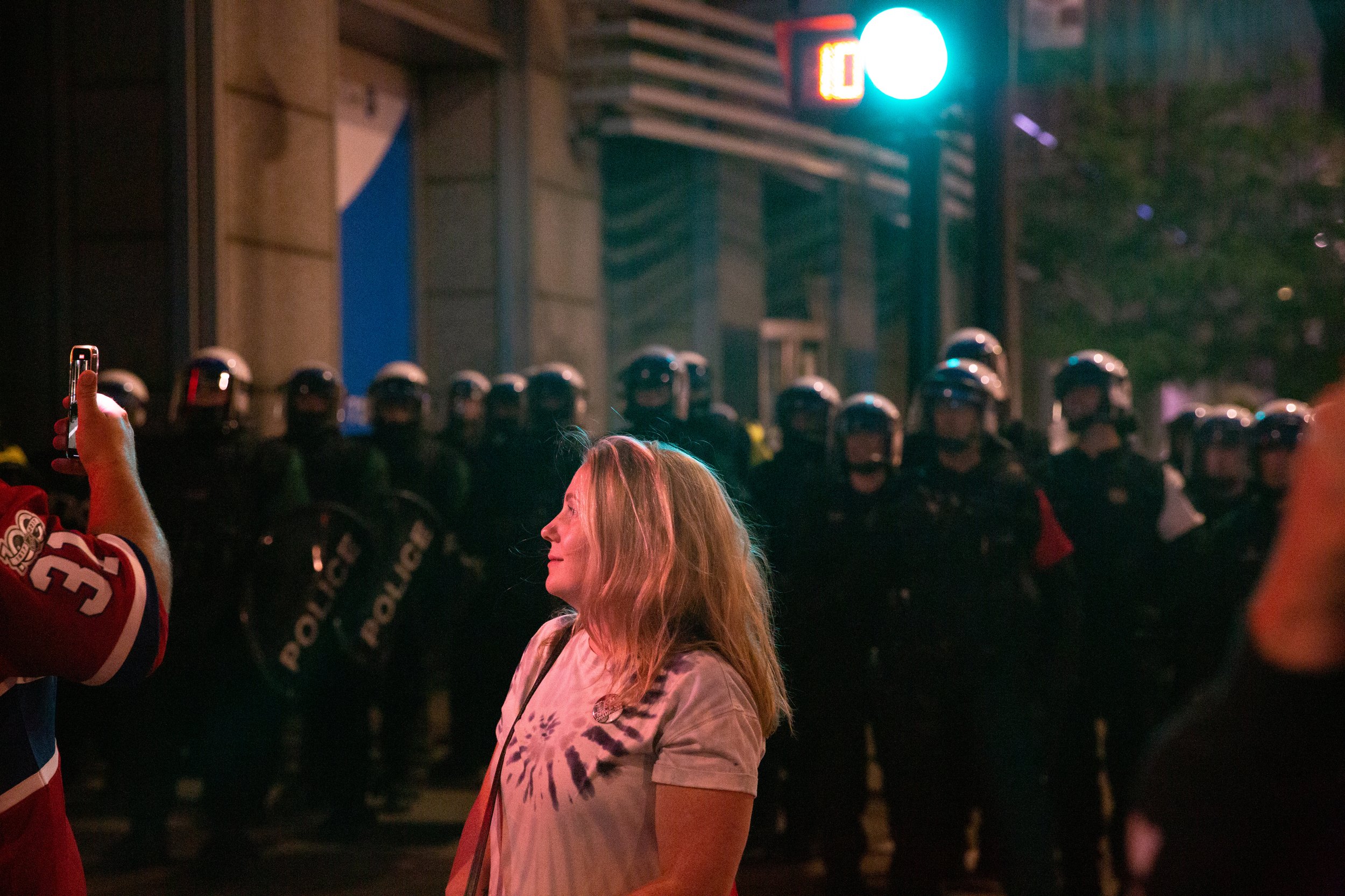  Montreal Canadiens fan standing in front of riot police in downtown Montreal in the aftermath of the team’s win against Tampa Bay Lightning. July 5, 2021.  