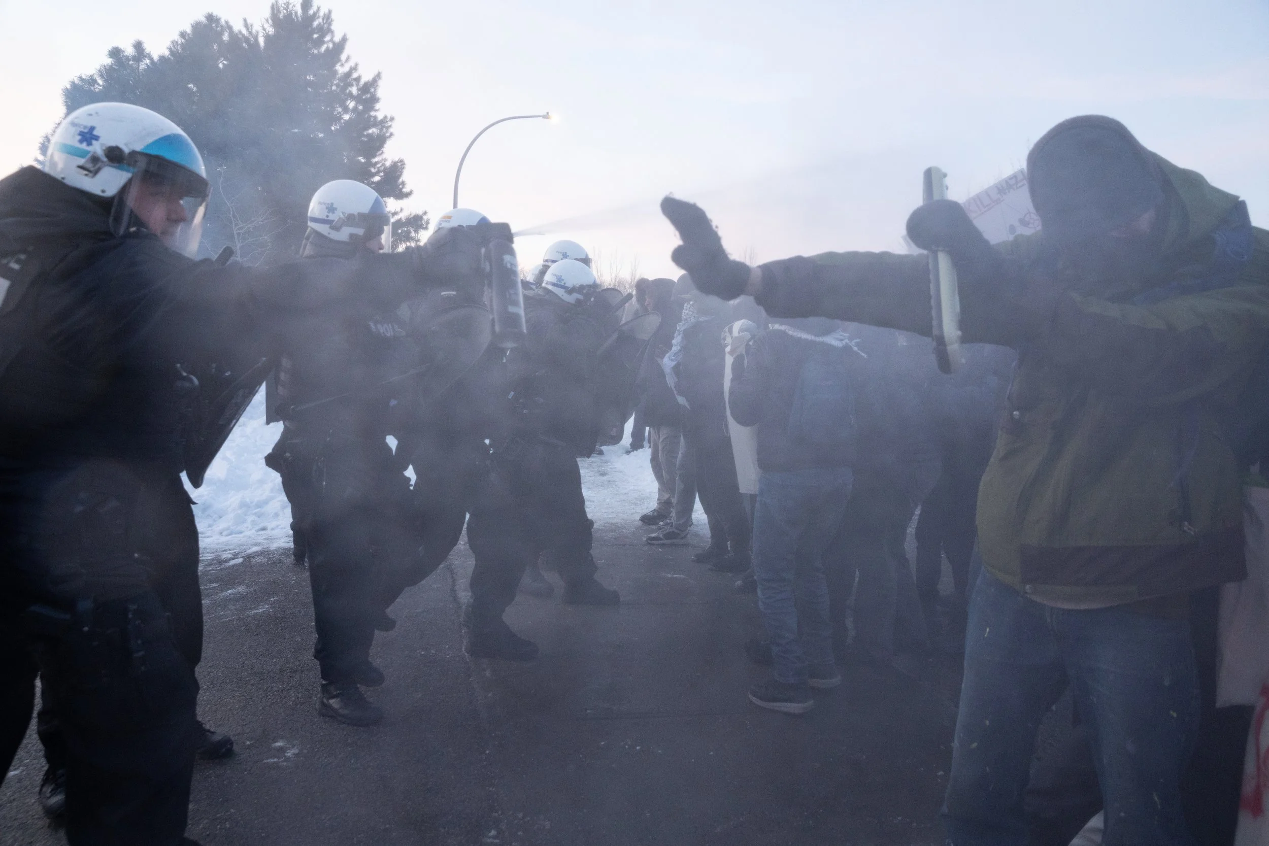  SPVM riot police pepper spraying demonstrators at a protest against private security company GardaWorld and their business with US’ ICE. St-Laurent, Montreal, Quebec. February 13, 2026.  