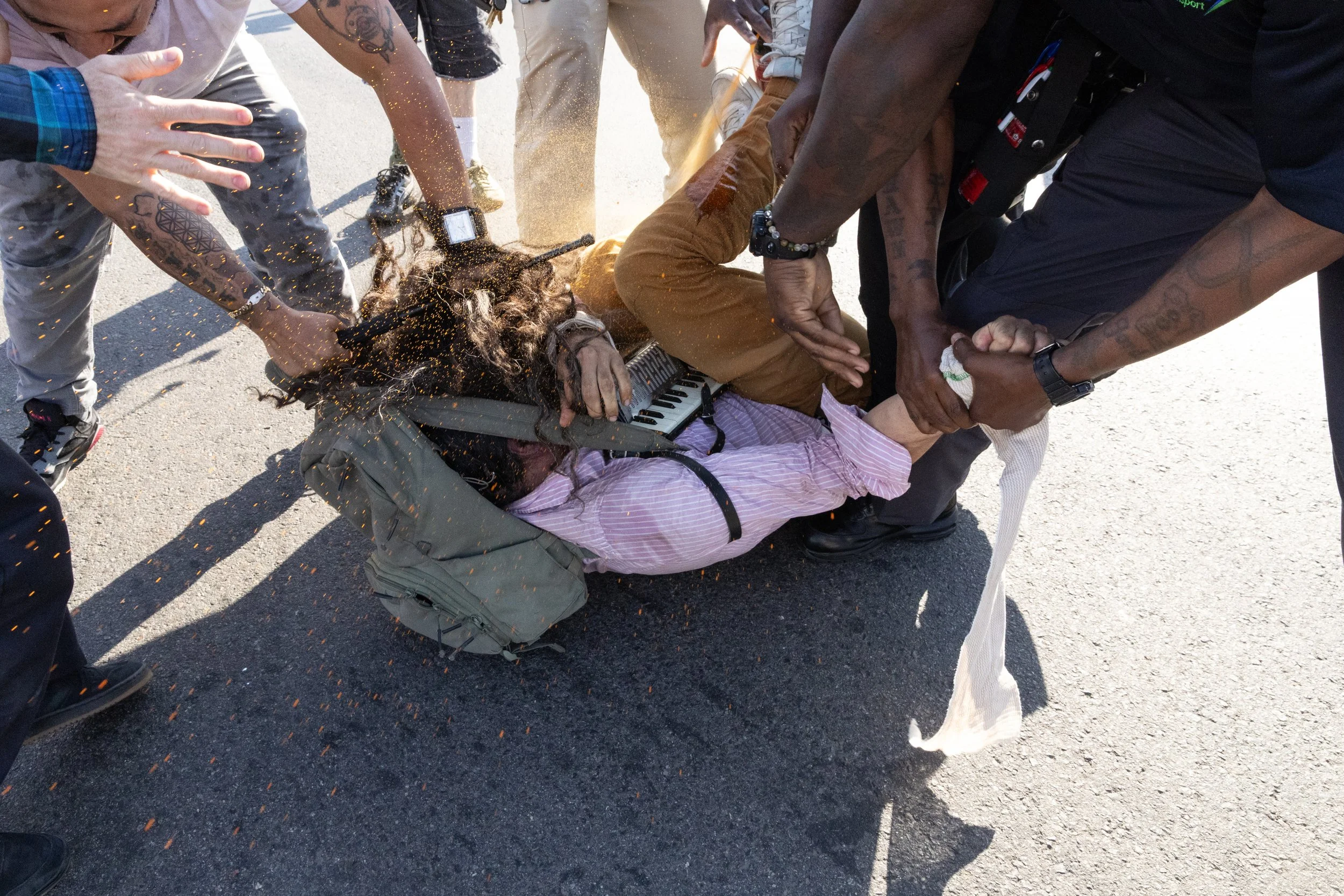  A demonstrator is pepper sprayed on the pavement by GEO Group employees while protesting outside Delaney Hall Detention Center. Newark, New Jersey. June 5, 2026. William Wilson. 
