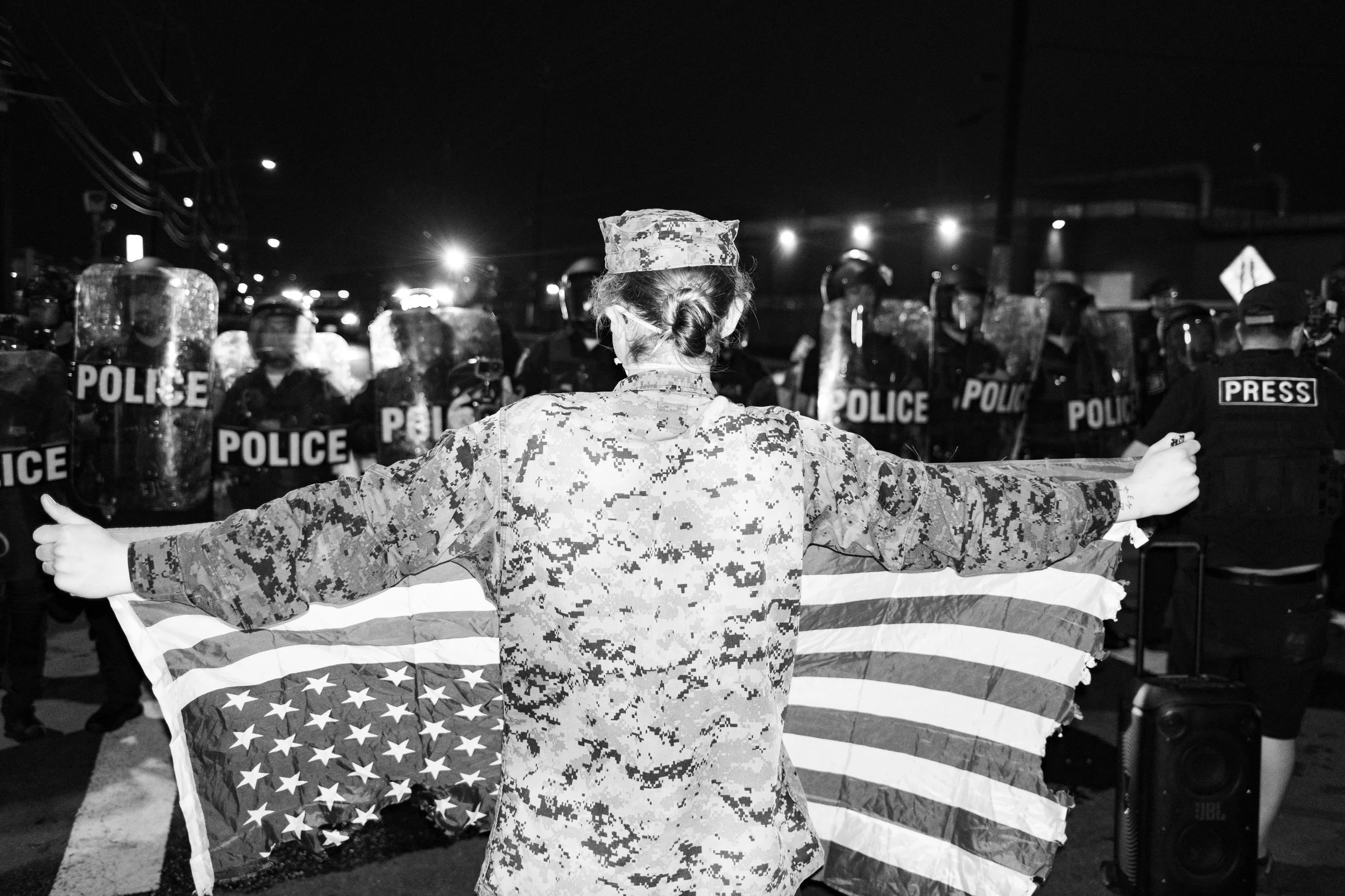  US veteran holds a US flag upside down at a protest outside ICE’s Delaney Hall Detention Center. Newark, New Jersey. June 6, 2026. William Wilson.  