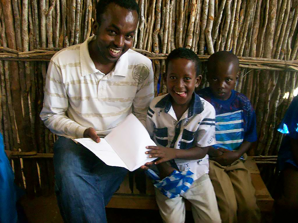   Abdi goes through books with two young students  