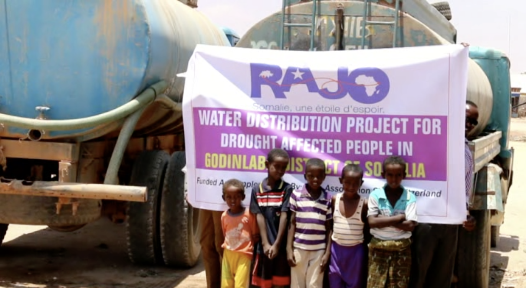   Children in front of a tanker truck about to deliver water  