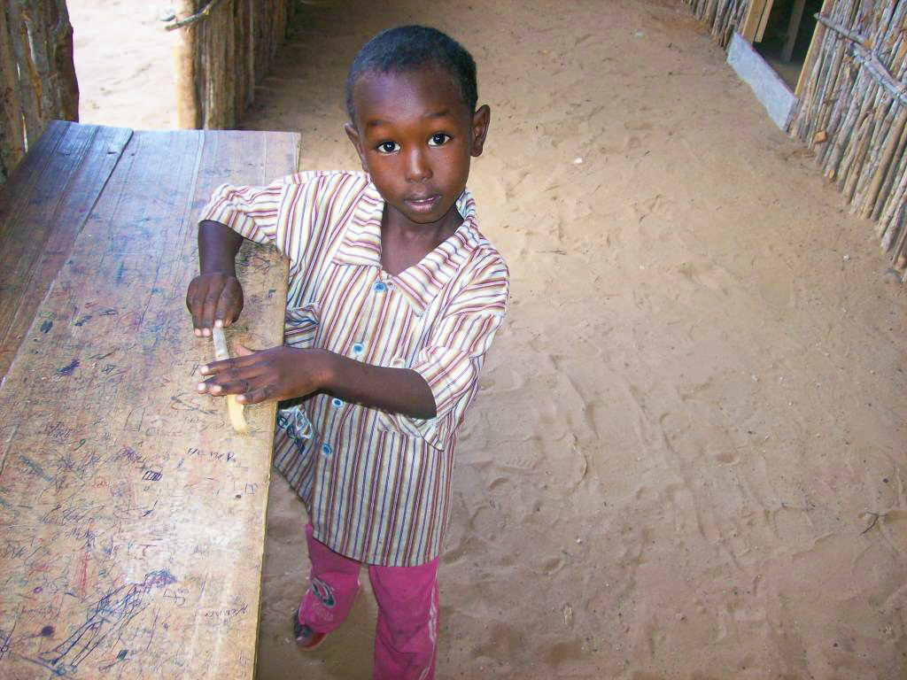 Il attend le retour de ses frères et sœurs qui sont partis à l’école. Camp Hawa Abdi, 2010