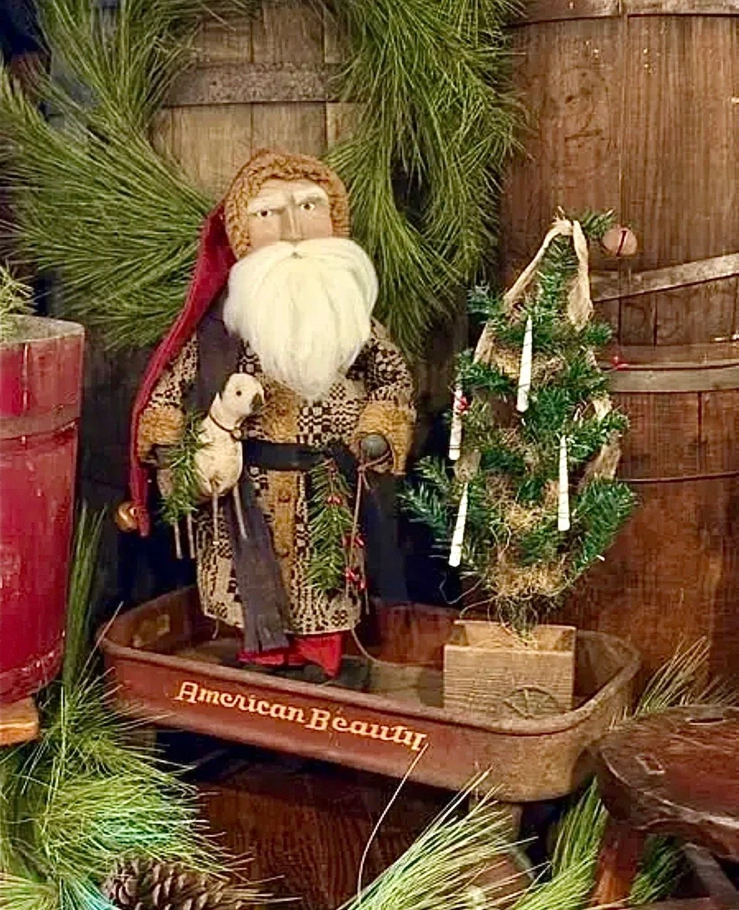 Santa Claus~$199.00 Clay face, wearing a coverlet jacket, pulling his tree 21” tall, tree is 19” tall