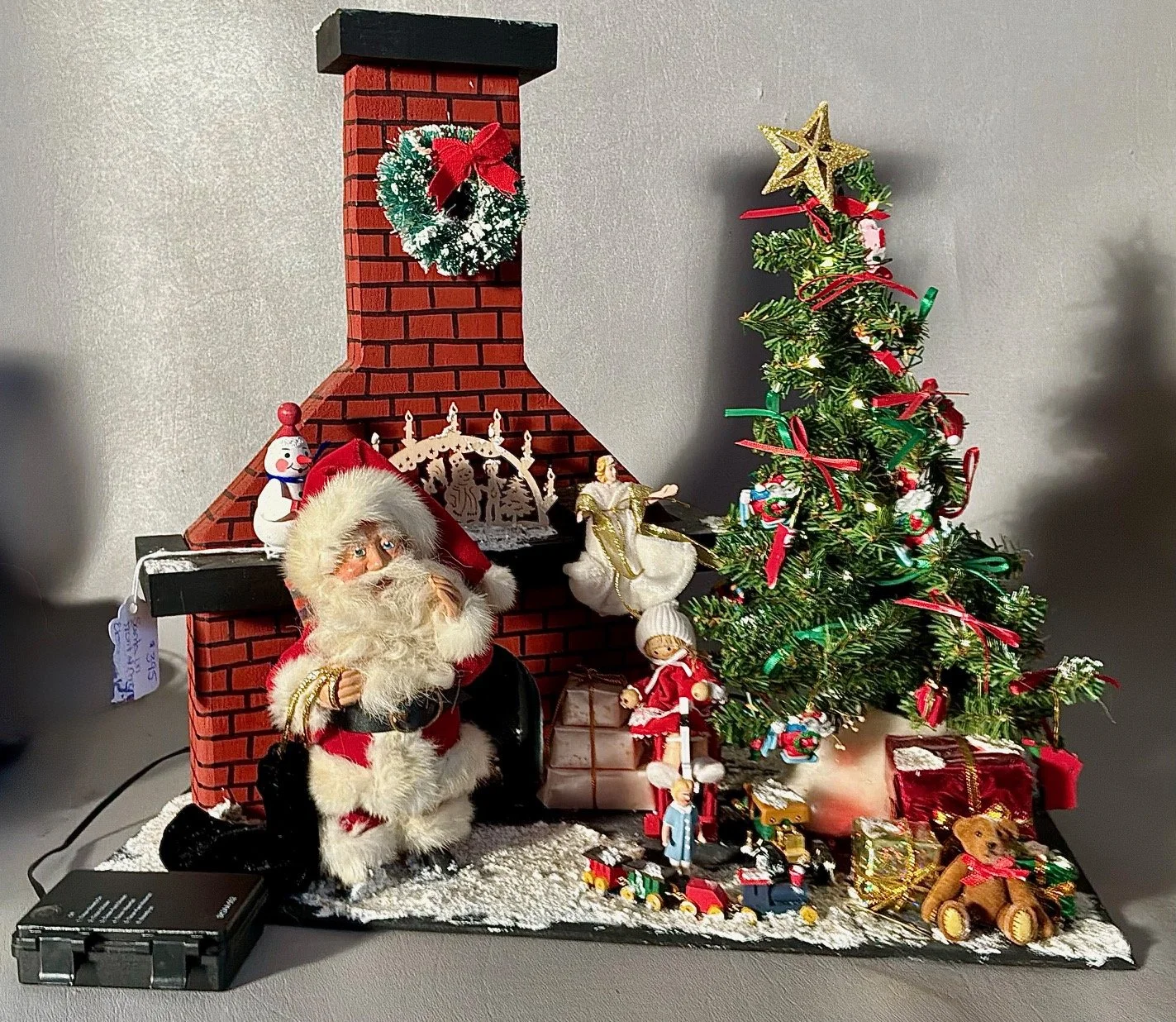Red Santa in front of Chimney with control for tree lights. $395.00            16” long & 14” tall