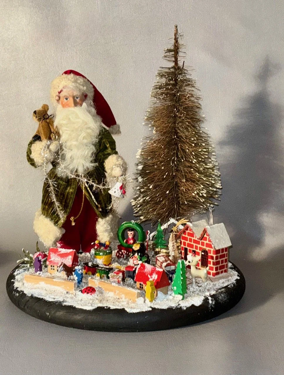 Green coat Santa with trees & toys $449.00           12” across & 13” tall