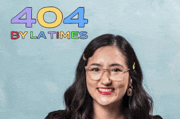 Woman with glasses smiling in front of a light blue background with a sign that reads '404 by LA Times'