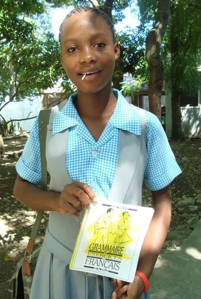 Junia and her lollipop show off her new school books and uniform