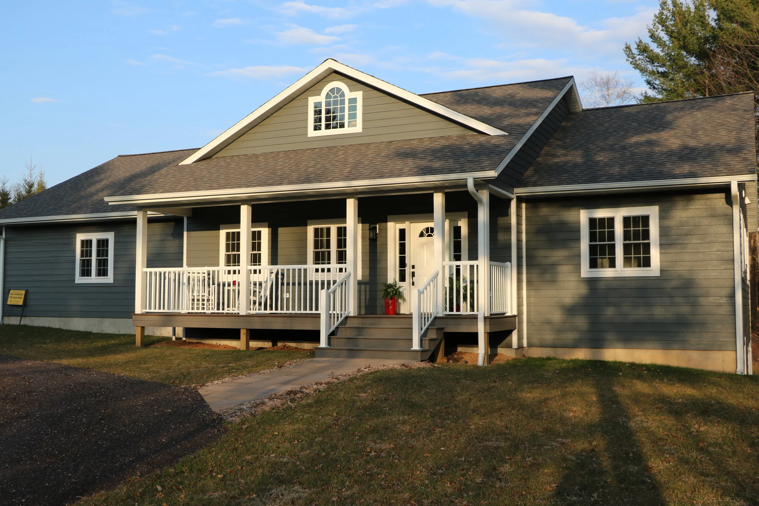 Custom residential ranch home construction with a covered front porch and stone siding accents, built by Schmidt Construction.
