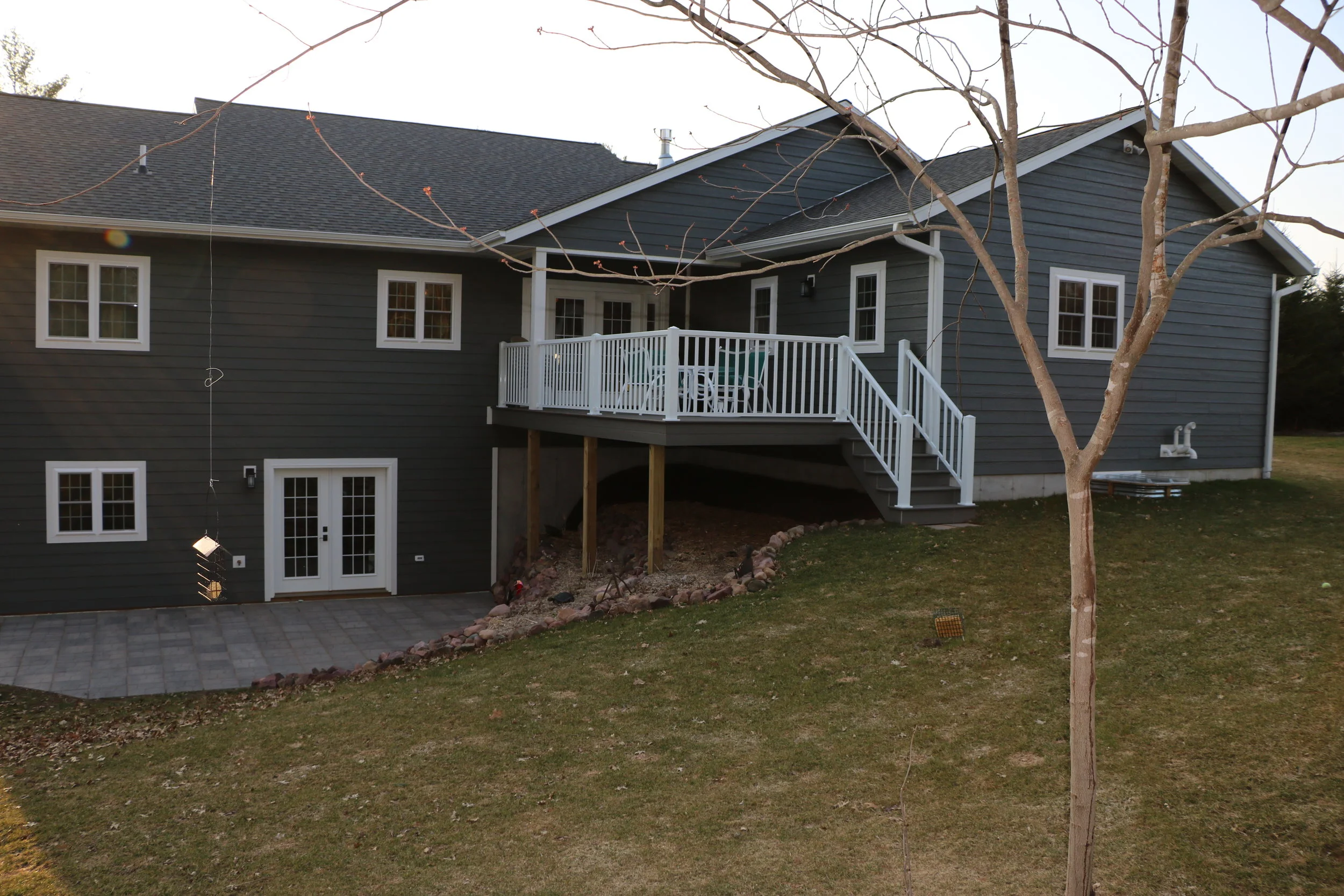 Custom two-story residential home construction featuring a modern raised walk-out deck, built by Schmidt Construction in Chetek, Wisconsin.