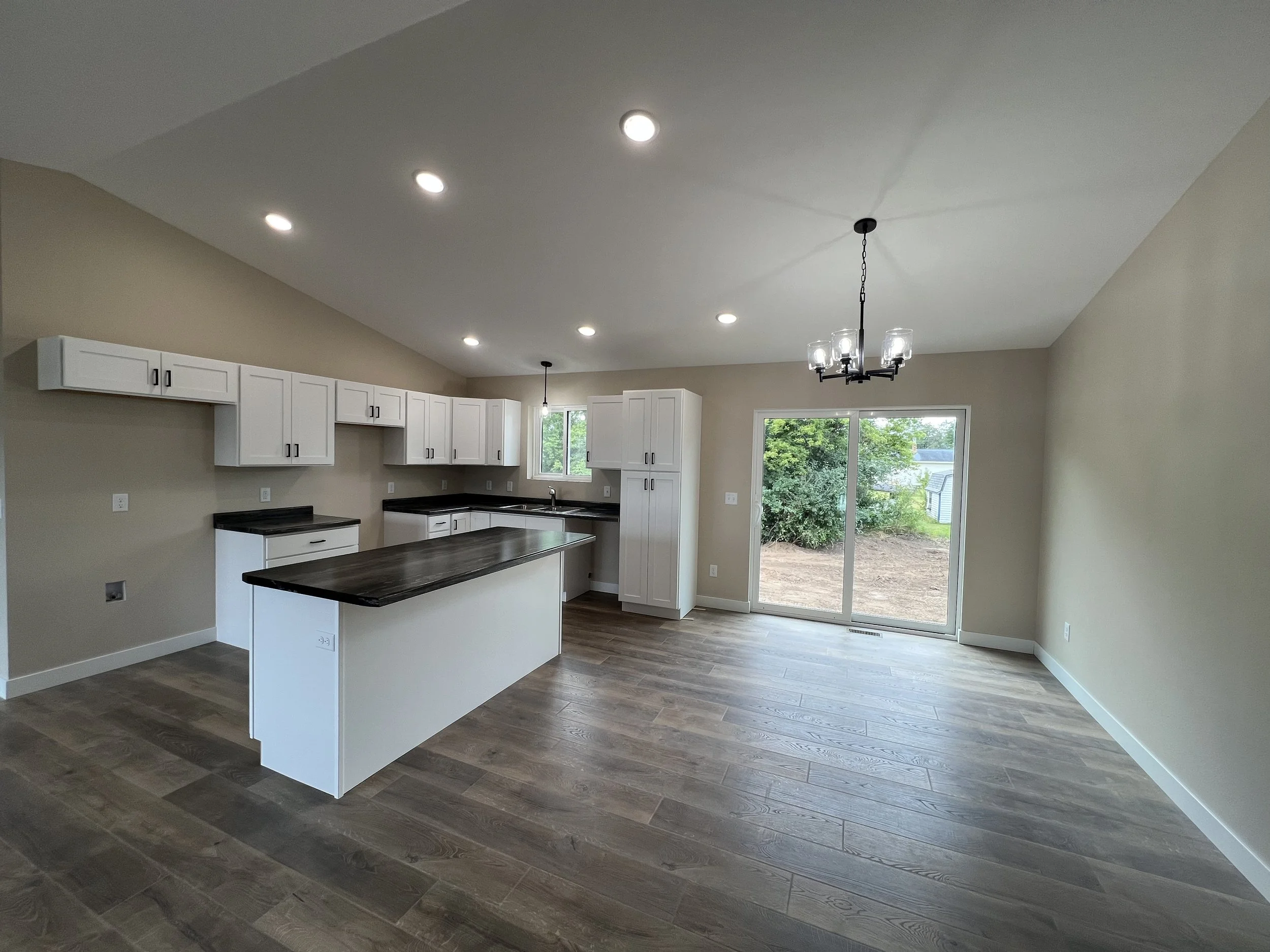 Modern open-concept kitchen remodeling and spacious living area design by Schmidt Construction in Chetek, WI.