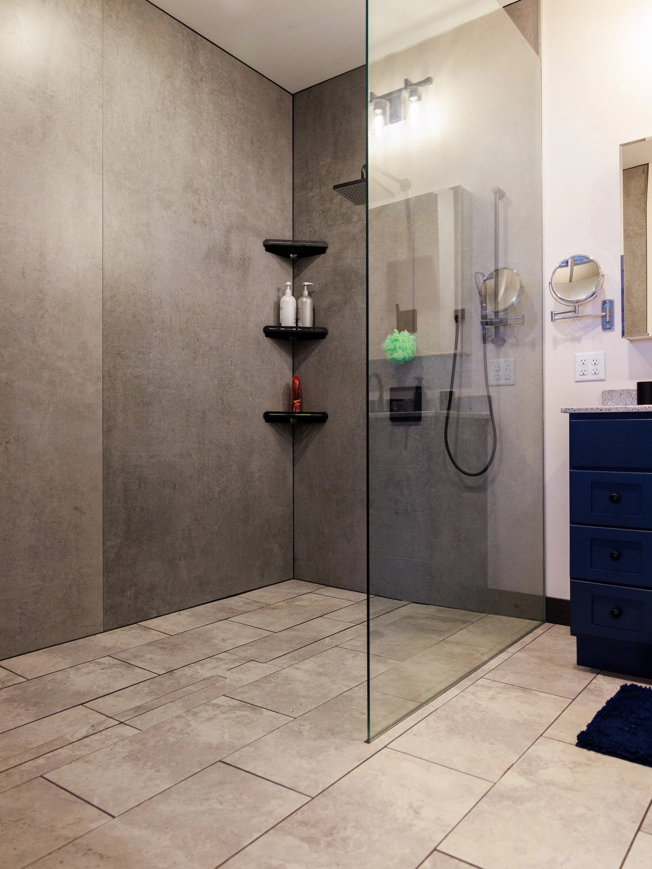 Luxury walk-in tiled shower with glass door and dual showerheads, custom-built for a home in Barron County by local contractors.