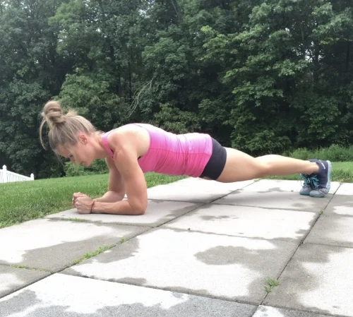 Middle plank position.  Keep shoulders over elbows while maintaining hollow body.  Think of sucking belly bottom in towards spine and squeeze your glutes.  