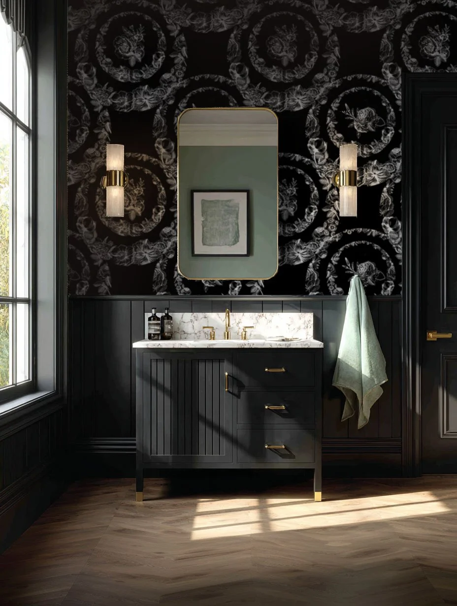 Luxury bathroom interior with black floral wallpaper, dark paneled vanity with brass hardware, gold-framed mirror, and modern wall sconces, styled with natural light and herringbone wood flooring; text overlay reads “Explore Our Packages.