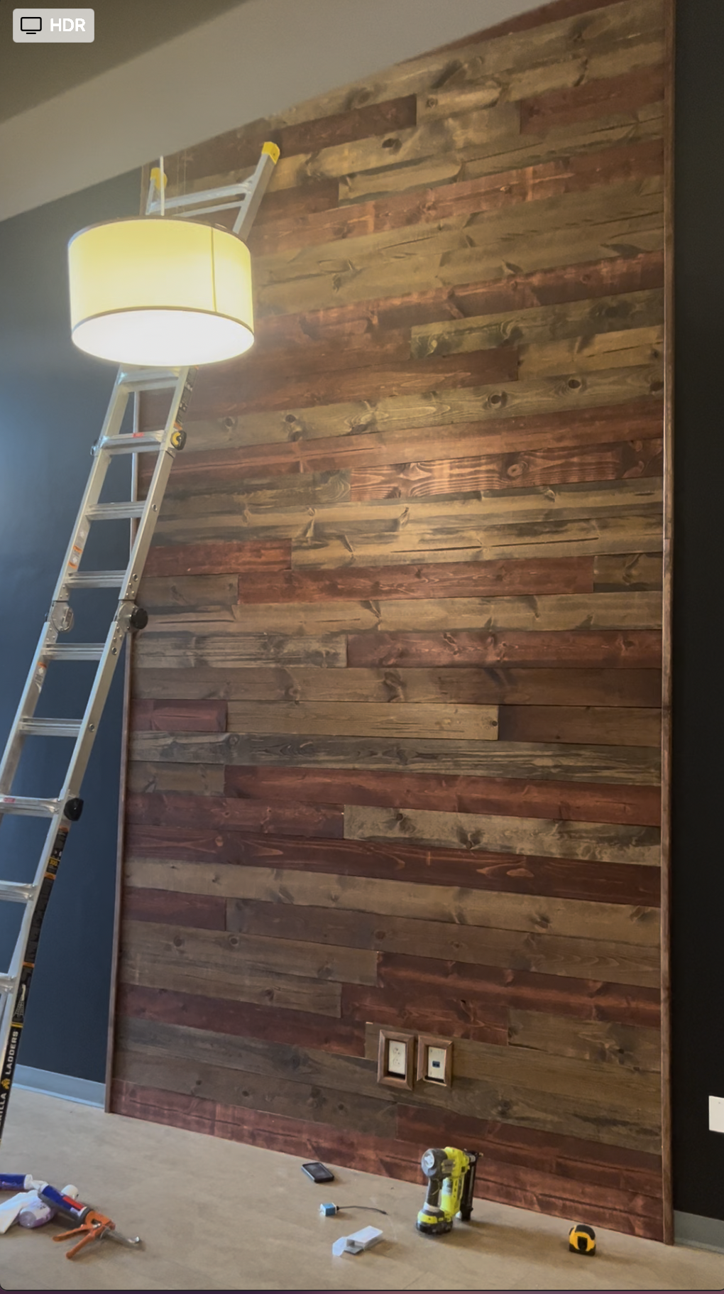 Reclaimed wood wall installation in progress at KC G.I.F.T. entryway.