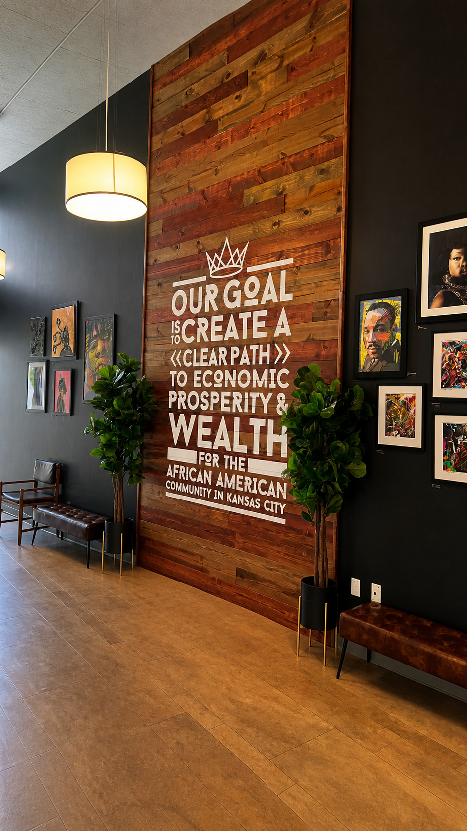 KC G.I.F.T. entryway featuring a reclaimed wood statement wall with bold mission typography, flanked by curated artwork, bench seating, and warm lighting—designed to reflect culture, community, and economic empowerment.