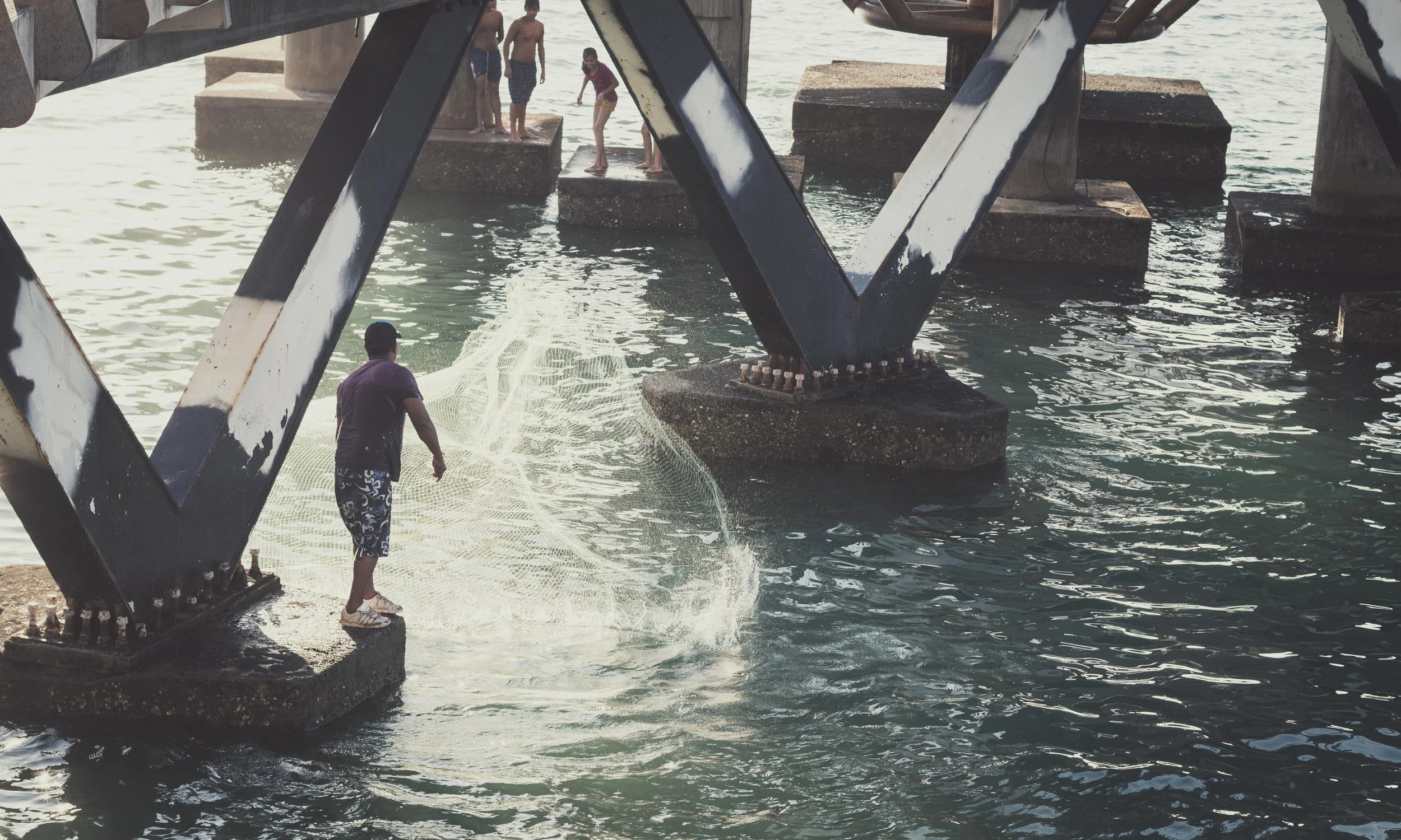 A fisherman working the waters off of Los Muertos Pier Puerto Vallarta Mexico. 