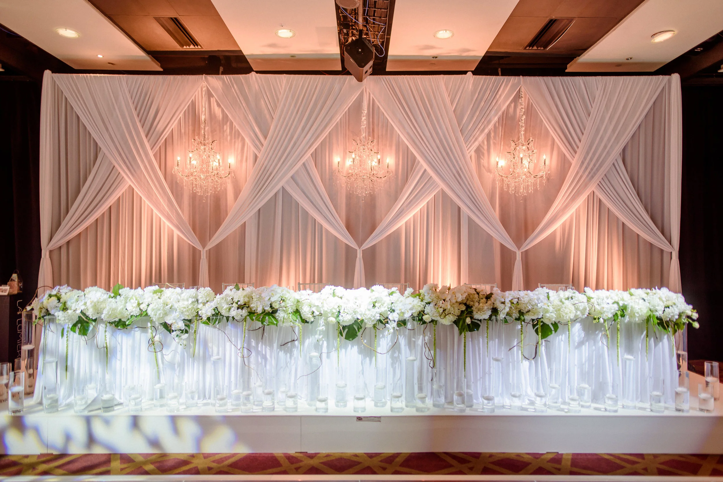 bespoke draped backdrop with chandeliers