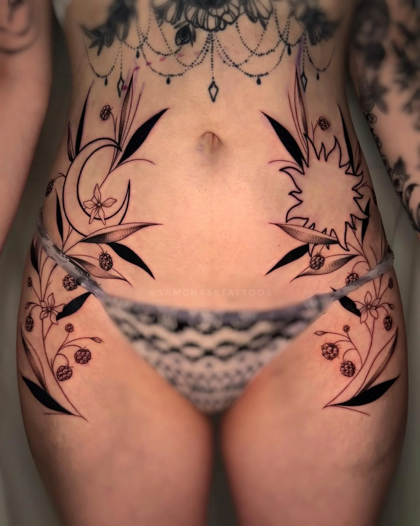 Had a lovely time creating these hip/tummy pieces for this client recently! 🌞🌙 Raspberries and leafies cradling the sun and moon. This will be extended down the thigh further in the future 🖤
Made using @emalla.official 
.
.
.
.
#hiptattoo #sunandm