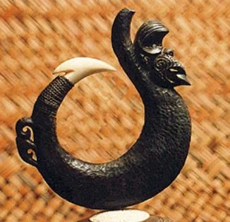 A bone and wood matau with ancestor figures added