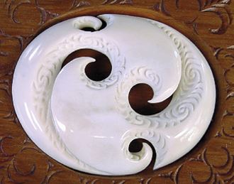 A carving showing the use of cut-out shapes with plain and textured surfaces to portray balance in multiple aspects