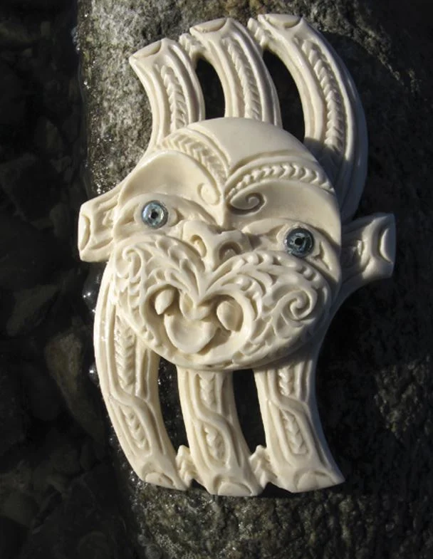 A carving of a figure with a face and many fingers, the essential elements of Pātangaroa, the starfish. While few would pick this as a starfish at first, the logic of its stylisation makes it easy to remember once it is identified
