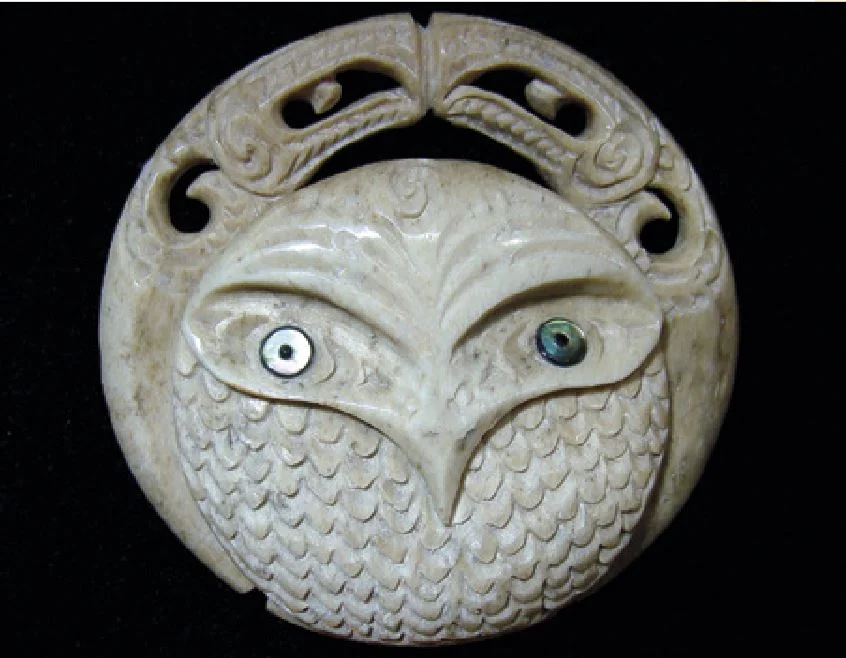 Owl carved as one of a set of circular guardian figures