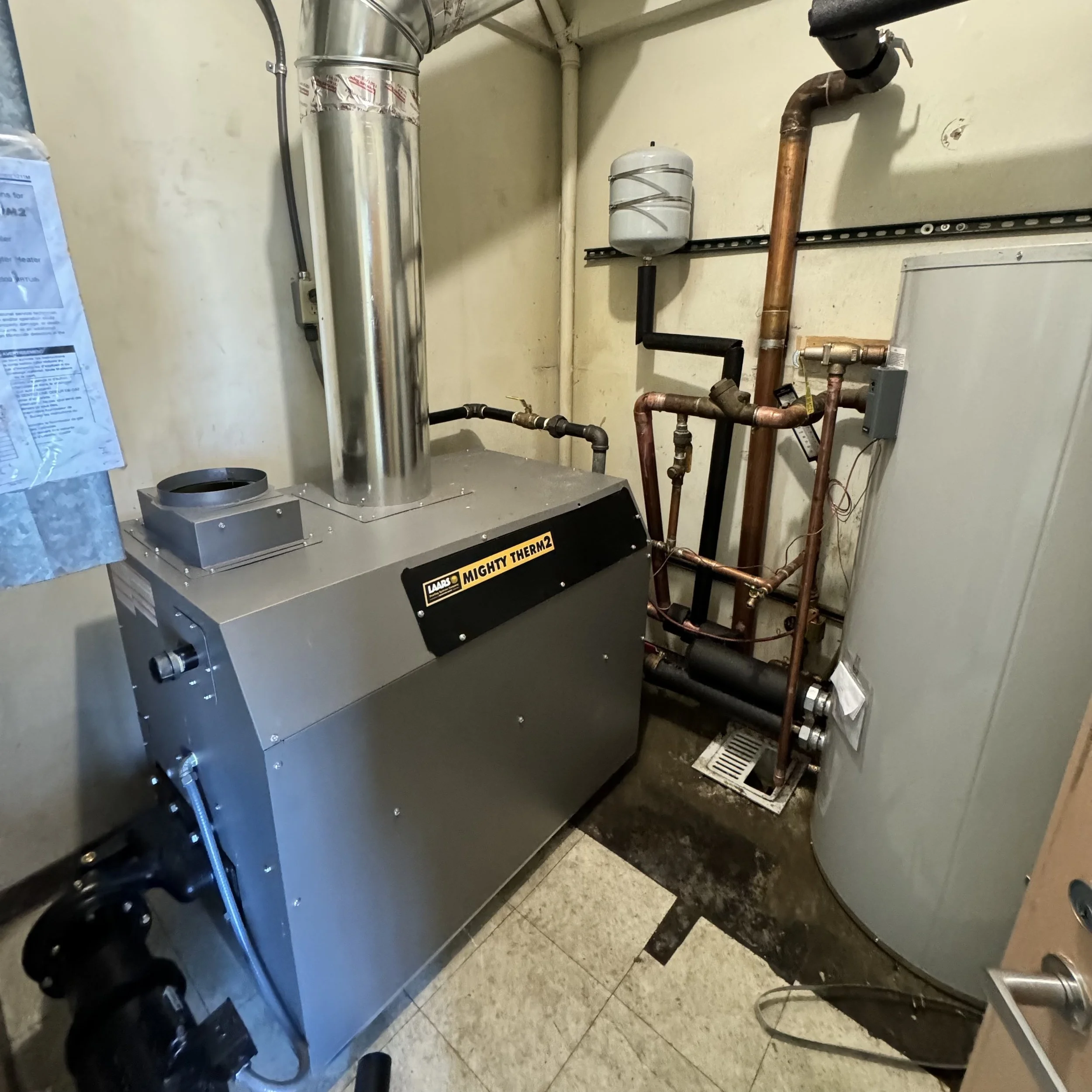 LAARS Mighty Therm 2 boiler installation with Bradford White 119-gallon storage tank at a commercial property in Bakersfield, CA, completed with permits by licensed plumbing contractor.