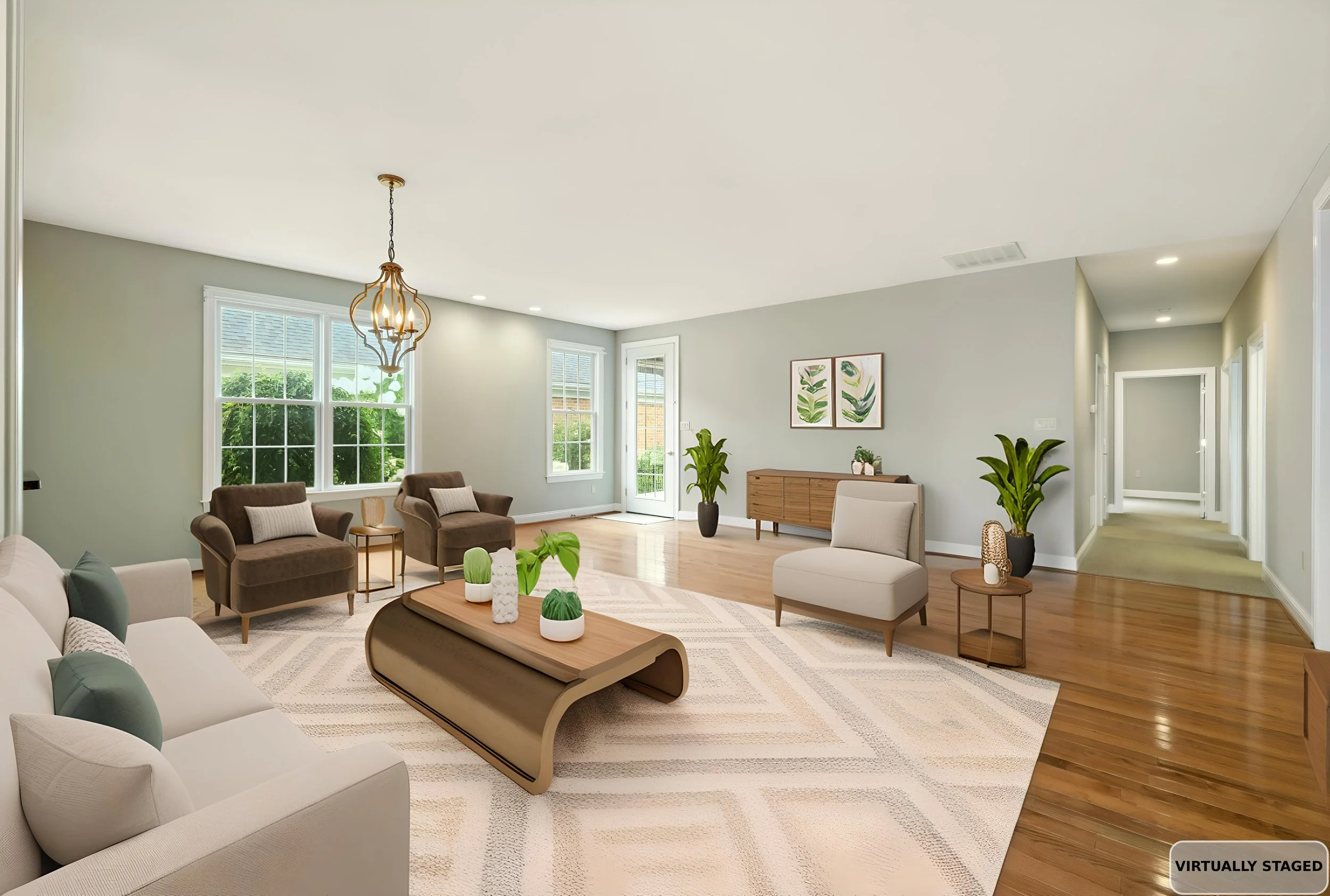 Living room with large windows, beige walls, modern furniture including white and brown chairs, a wooden coffee table with decorative items, green plants, and wall art. Overhead lighting includes a chandelier and recessed lights. The image has a labe